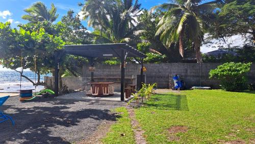 a garden with a picnic shelter and a trash can at TAHITI - Motu Nono Beach View in Atihiva