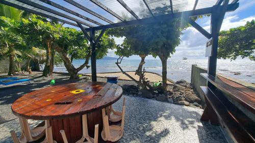 a wooden table on the beach with a bench at TAHITI - Motu Nono Beach View in Atihiva