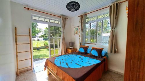 a bedroom with a bed and a large window at TAHITI - Motu Nono Beach View in Atihiva