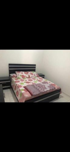 a bedroom with a bed with a floral comforter at Dalina الساحل الشمالي قدام مراسي in El Alamein