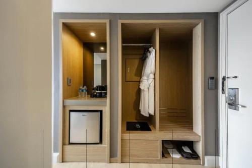 a bathroom with a closet with a robe on the door at Lahan Hotel Jeonju in Jeonju