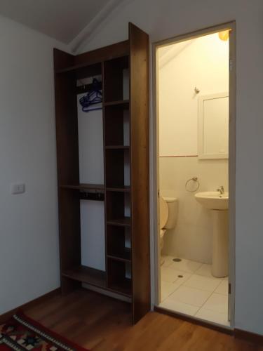 a bathroom with a toilet and a glass door at Casa Turística Las Tunas - Habitación: Apu Marcahuiri in Sicuani