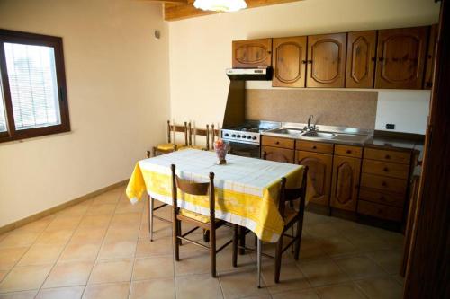 uma cozinha com uma mesa com uma toalha de mesa amarela em A Casitta a pochi km da Taormina em Calatabiano