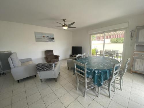 un salon avec une table, des chaises et un canapé dans l'établissement Maison récente calme à Fouras, près de la mer, 3 chambres, terrasse, garage et parking - FR-1-709-40, à Fouras
