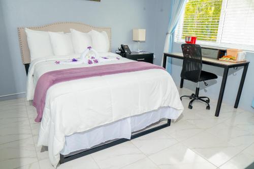 a bedroom with a bed and a desk and a chair at Lavender Moon Villas in Breadnut Hill