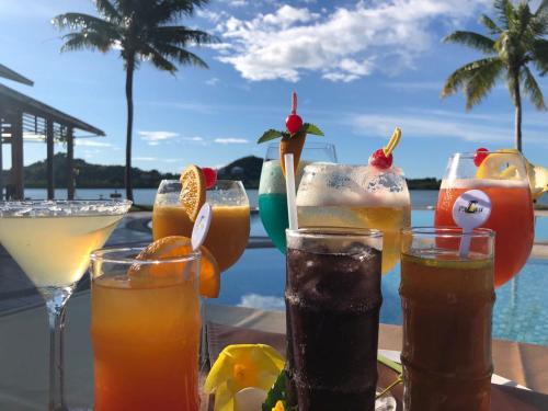 a group of drinks on a table next to a pool at Island Paradise Resort Club in Koror