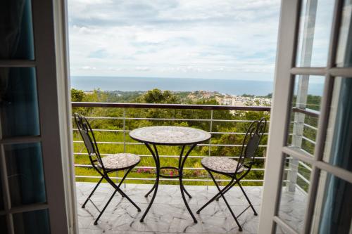 a table and chairs on a balcony with a view at Lavender Moon Villas in Breadnut Hill