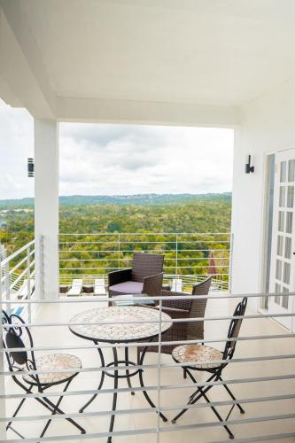 a patio with a table and chairs on a balcony at Lavender Moon Villas in Breadnut Hill