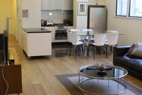 a living room with a couch and a table and a kitchen at The Walkup Southbank in Melbourne