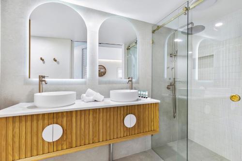 a bathroom with two sinks and a shower at Noosa Blue Resort in Noosa Heads