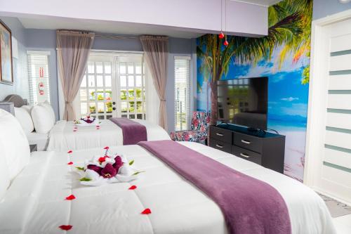 Habitación de hotel con 2 camas y TV en Lavender Moon Villas, 