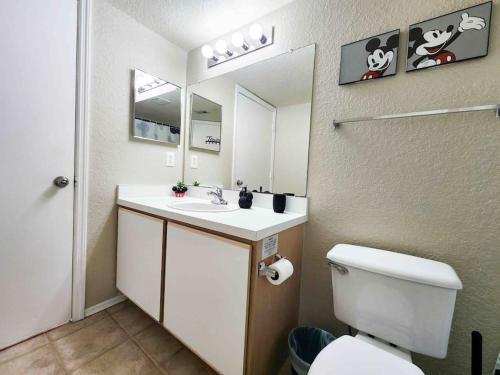 a bathroom with a toilet and a sink and a mirror at Cozy & spacious 2 BR / 2 BA condo in Kissimmee