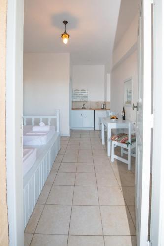 a white room with a tile floor and a kitchen at Karpathios Studios Pefkos in Pefki Rhodes