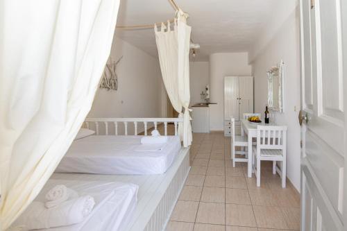 a bedroom with a bed and a table and chairs at Karpathios Studios Pefkos in Pefki