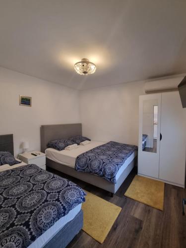 a bedroom with two beds and a chandelier at Apartman Migliore in Sesvete