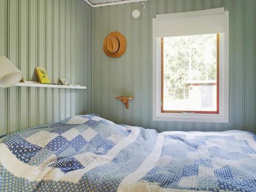 ein Schlafzimmer mit einem Bett mit einer blau-weißen Decke in der Unterkunft Holiday home GRISSLEHAMN XIII in Grisslehamn