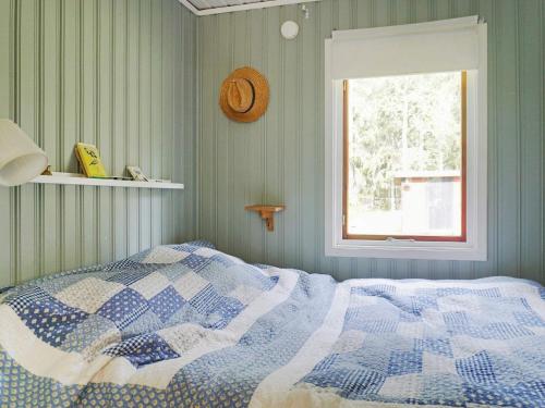 a bedroom with a bed with a blue and white quilt at 5 person holiday home in GRISSLEHAMN-By Traum in Grisslehamn