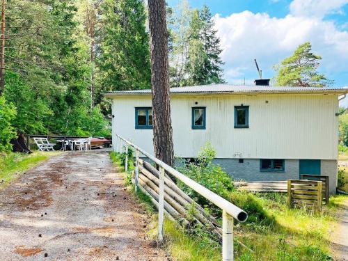 a white house with a fence next to a dirt road at 6 person holiday home in HENÅN-By Traum in Henån
