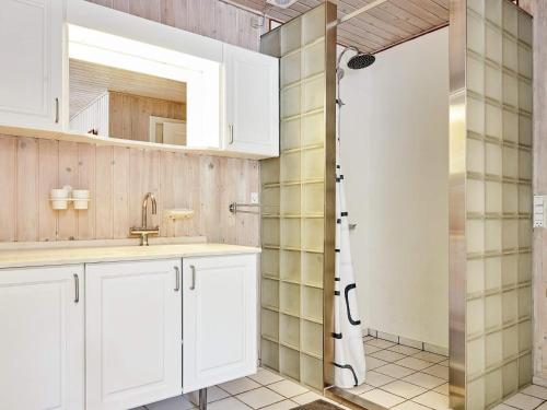 La salle de bains est pourvue d'un lavabo et d'une douche. dans l'établissement Holiday home Aakirkeby LXIII, à Vester Sømarken