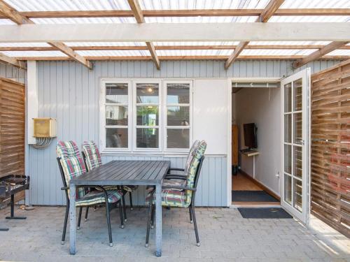 a table and chairs on a patio with a pergola at 4 person holiday home in Sydals in Østerby