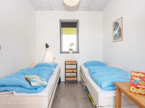 2 łóżka w pokoju z niebieskimi poduszkami w obiekcie Holiday home Aabenraa LXXIV w mieście Aabenraa