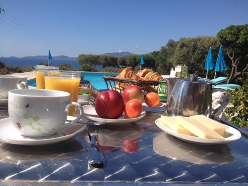 a table with a breakfast of fruit and bread and juice at Hotel Celine in Coti-Chiavari