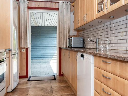 a kitchen with wooden cabinets and a door leading to a hallway at Luxury Retreat by Bonnerup - By Traum Ferienwohnungen in Glesborg