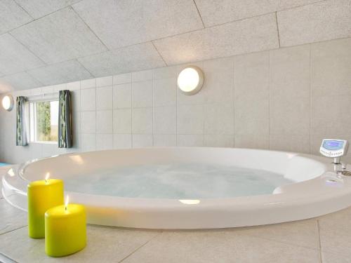Holiday home Sydals LXXXVI في Sønderby: حوض استحمام مع شموعين في الحمام