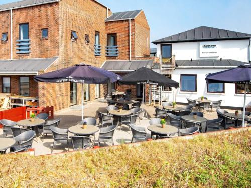 a patio with tables and chairs and umbrellas at Apartment in Holiday park- shared kitchen in Ulfborg