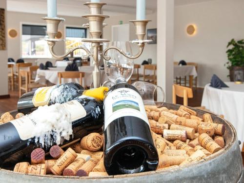 two bottles of wine are being poured into a barrel at Apartment in Holiday park- shared kitchen in Ulfborg