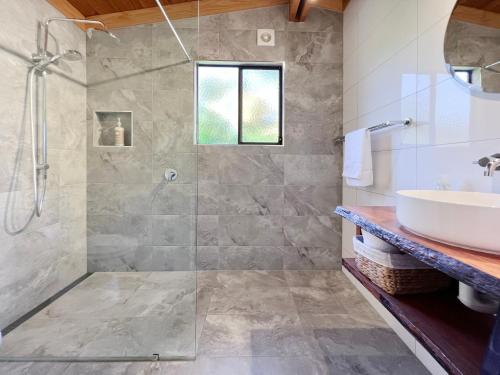 y baño con ducha y lavamanos. en HEXAGON BEACH HOUSE Binalong Bay of Fires Views en Binalong Bay