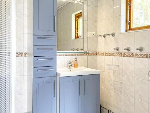 uma casa de banho com um armário azul e um lavatório em Holiday home Rejmyre II em Rejmyre