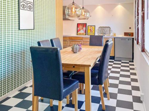 a dining room with a wooden table and blue chairs at Holiday home Västervik III in Västervik