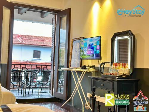 a room with a sliding glass door with a view of a balcony at Wayfarer Guest House Jonker Street Melaka By Heystay Management in Melaka