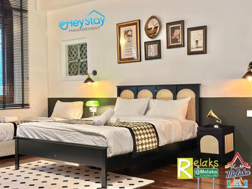 a bedroom with two beds and pictures on the wall at Wayfarer Guest House Jonker Street Melaka By Heystay Management in Melaka