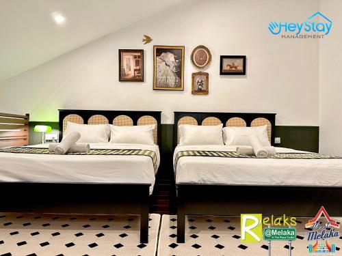 two beds sitting next to each other in a room at Wayfarer Guest House Jonker Street Melaka By Heystay Management in Melaka