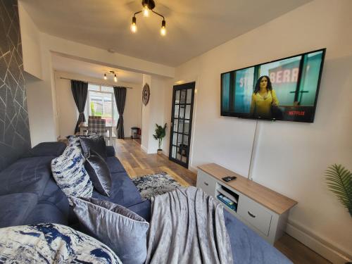 a living room with a couch and a tv on a wall at Cosy Home Ideal for Business, Contractors, Families near Walsgrave Hospital, Shops and M6, A46, Free Parking in Wyken