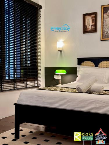 a bedroom with a large bed and a green lamp at Wayfarer Guest House Jonker Street Melaka By Heystay Management in Melaka