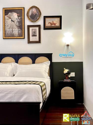 a bedroom with a bed and some pictures on the wall at Wayfarer Guest House Jonker Street Melaka By Heystay Management in Melaka