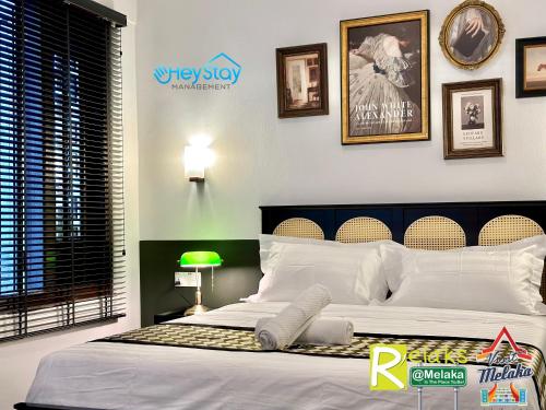a bedroom with a large bed with white pillows at Wayfarer Guest House Jonker Street Melaka By Heystay Management in Melaka