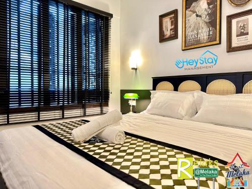 a bedroom with a large bed with a checkered floor at Wayfarer Guest House Jonker Street Melaka By Heystay Management in Melaka