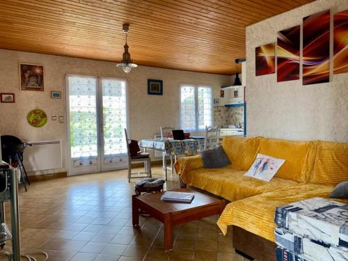 un salon avec un canapé et une table dans l'établissement Maison de Vacances : Plage, Forêt et Calme à Longeville-sur-Mer - FR-1-336-113, à Longeville-sur-Mer