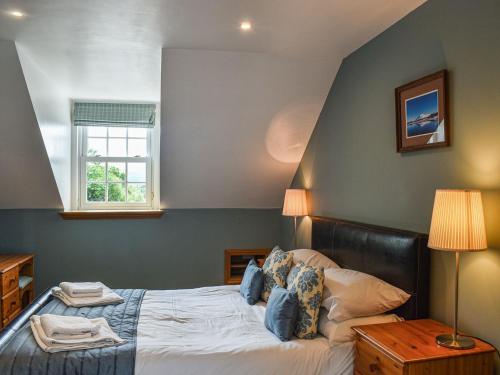 Salen的住宿－Frasers Cottage，一间卧室设有一张大床和一个窗户。