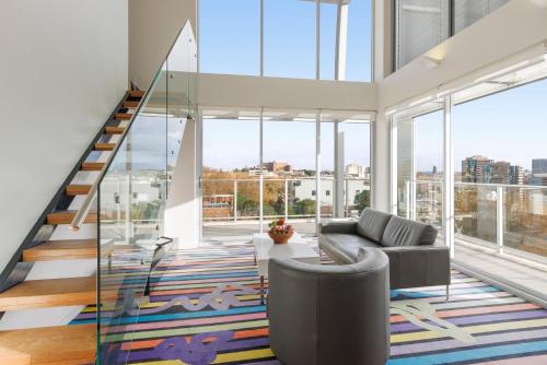 a living room with a staircase and a couch at Adge Hotel and Residences in Sydney