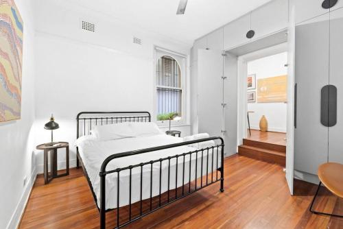 1 dormitorio blanco con 1 cama y suelo de madera en Kings 2 Self- Catering, en Sídney