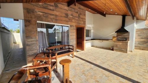 una sala de estar con una pared de madera y sillas de madera. en Casa Peruibe com Piscina Mtk2, en Peruíbe
