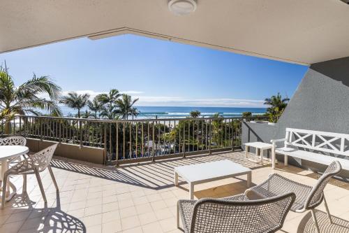 a patio with chairs and tables and a view of the ocean at The Rocks Resort Unit 3C in Gold Coast