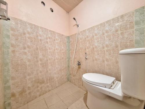 a bathroom with a toilet and a shower at RedDoorz Syariah near Pasar Raya Padang in Padang