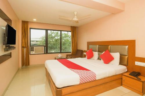 a bedroom with a large bed with red pillows at OYO Hotel Sarovar Grand in Kalamboli