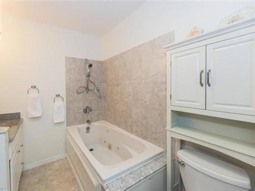 a bathroom with a white tub and a white cabinet at Amazing view of 4 bedrooms, 3 bathrooms 4-season cottage in Wiarton